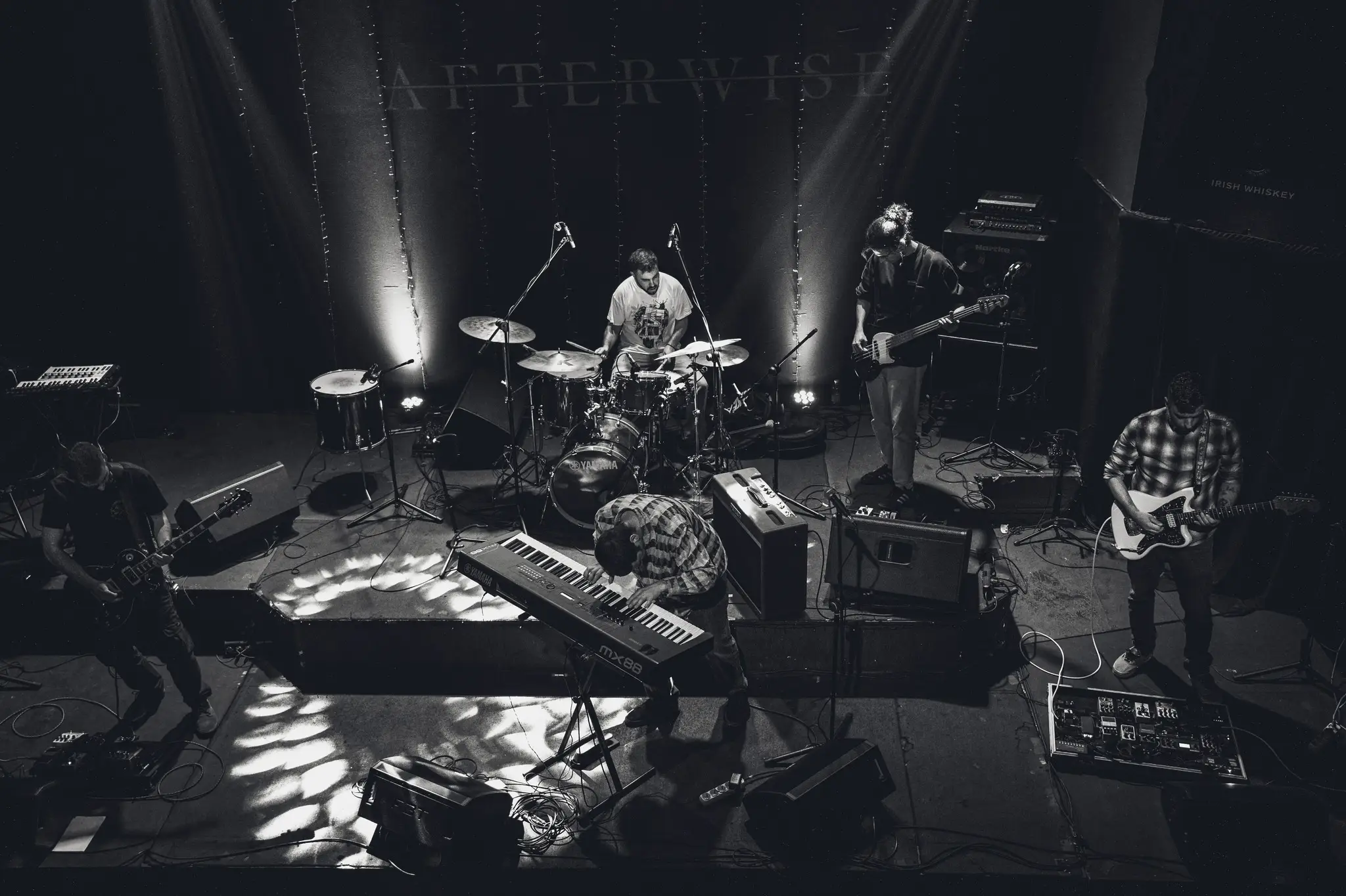 Afterwise performing live on a black-and-white stage