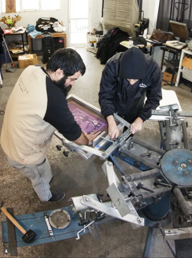 Workshop scene with a person preparing a t-shirt with a heat press